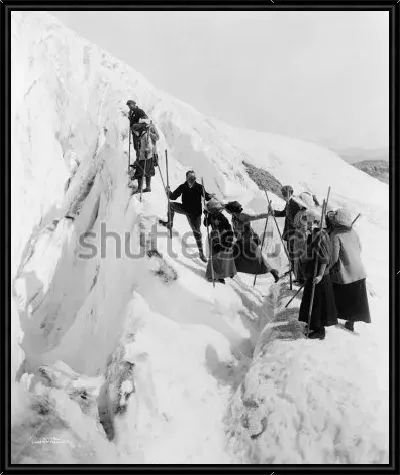 Картина Группа мужчин и женщин совершает восхождение на вершину заснеженной скалы в Национальном парке штата Вашингтон (фото 1915 года)