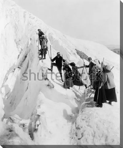 Постер Группа мужчин и женщин совершает восхождение на вершину заснеженной скалы в Национальном парке штата Вашингтон (фото 1915 года)