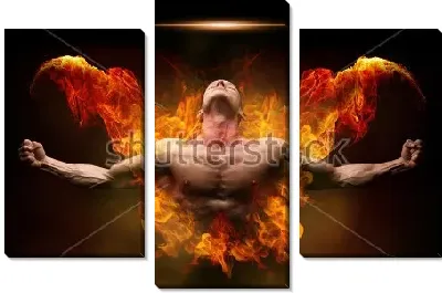 Молодой культурист с раскрытыми руками объят пламенем огненных крыльев за спиной