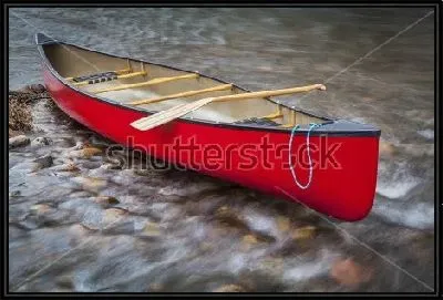 Каноэ с веслом на мелководье бурной реки