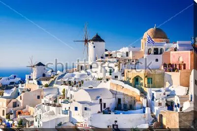 Прекрасный город Ия с бело-голубыми домами и мельницами на побережье Эгейского моря (о.Санторини, Греция)