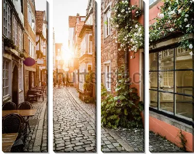 Красивое закатное солнце на старинной улочке Шнорс кофейнями и магазинчиками в Бремене