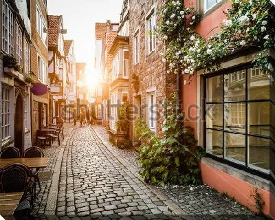 Постер Красивое закатное солнце на старинной улочке Шнорс кофейнями и магазинчиками в Бремене