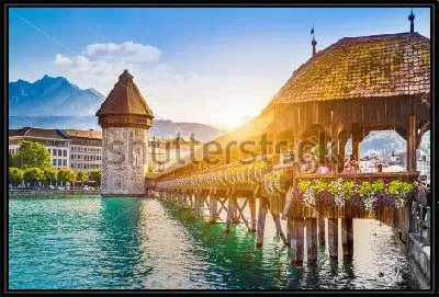 Картина Залитой золотым солнечным светом крытый деревянный мост через озеро и вид на башню в исторической части города в Люцерне