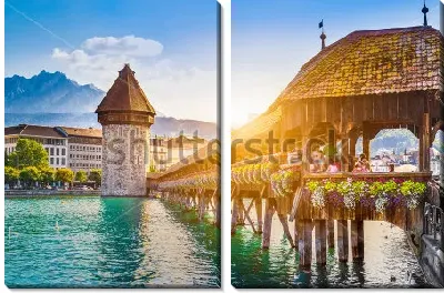 Залитой золотым солнечным светом крытый деревянный мост через озеро и вид на башню в исторической части города в Люцерне