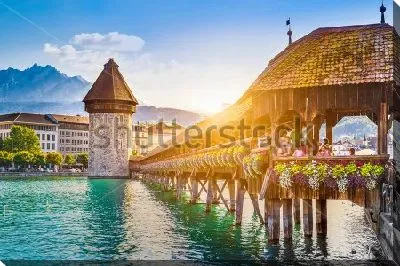Постер Залитой золотым солнечным светом крытый деревянный мост через озеро и вид на башню в исторической части города в Люцерне