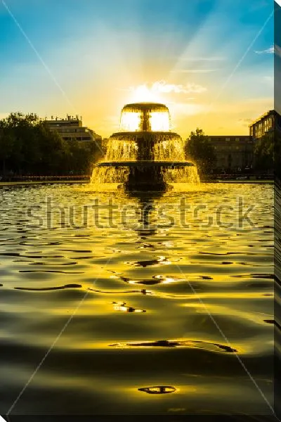 Постер Красивый золотой закат в брызгах фонтана в городском парке Висбадена