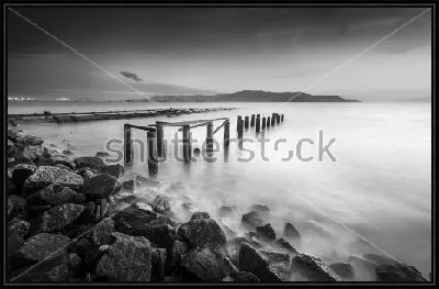 Уходящий вдаль морской пирс на фоне гор