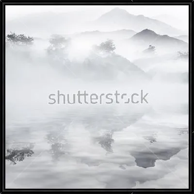Монохромный пейзаж с туманом в горах и отражением в озере