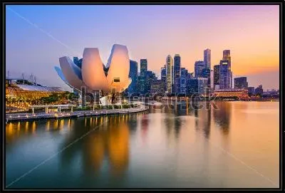 Вечерний пейзаж набережной Сингапура с небоскрёбами и зданием в виде распускающегося цветка