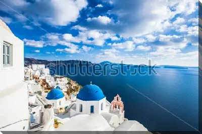 Красивый пейзаж с видом на море и небо со стороны улицы с белоснежными домами и синими куполами в Санторини (Греция)