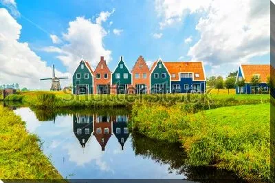 Красивый колоритный пейзаж с цветными домиками и мельницей в Волендаме (Северная Голландия)