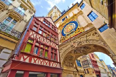 Плакат Фрагмент с яркими домами средневековой архитектуры и большими уличными часами над аркой в Руане (Франция)