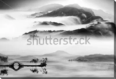 Прекрасный монохромный пейзаж в стиле китайской живописи тушью - высокие горы в тумане и красивый мостик на озере