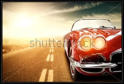 Роскошный красный автомобиль мчится по залитой солнцем трассе