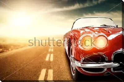 Роскошный красный автомобиль мчится по залитой солнцем трассе