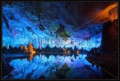 Красиво подсвеченная пещера "Хрустальный дворец короля драконов" с отражением в озере в Гуйлине (Китай)