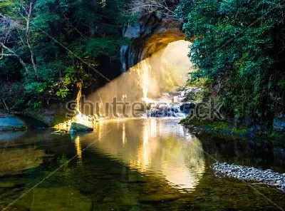 Плакат Луч света освещает вход в прекрасную пещеру с озером в Чибе (Япония)