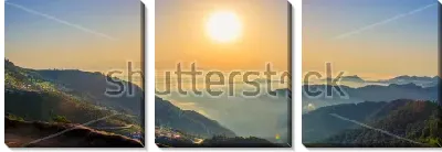 Модульная картина Красивый панорамный пейзаж с облаками на горных вершинах и большим солнцем