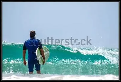 Серфер ждёт океанскую волну на побережье Новой Зеландии