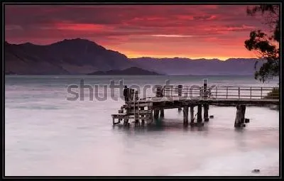 Картина Великолепный закат над величественными горами вдоль озера с деревянным пирсом