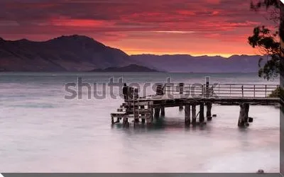 Постер Великолепный закат над величественными горами вдоль озера с деревянным пирсом