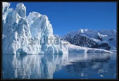 Ледник Антарктиды на фоне ясного голубого неба и спокойной глади океана