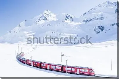 Чудесный зимний пейзаж с красным поездом, мчащимся по заснеженной долине в швейцарских Альпах