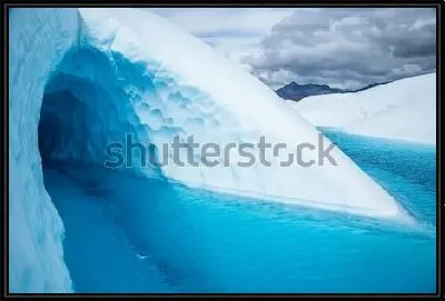 Большой вход в ледяную пещеру на леднике Матануска, затопленный голубой водой (Аляска)