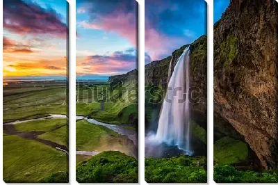 Великолепный пейзаж зелёной долины с «Парящим водопадом» Сельяландсфосс в Исландии