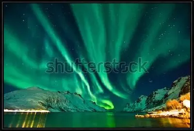 Фантастический пейзаж с переливами северного сияния над снежными горами в Тромсё (Норвегия)