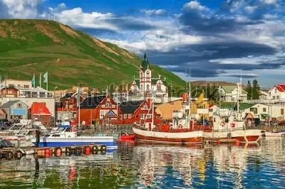 Плакат Прекрасный вид на исторический город Хусавик с традиционными разноцветными домами и рыбацкими лодками (Исландия)