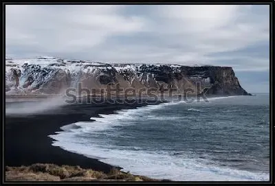Суровый великолепный пейзаж с прибоем на пляже с чёрным песком на фоне горных хребтов (Исландия)