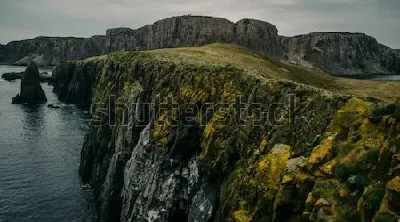 Плакат Скалы на берегу моря с зелёным и оранжевым мхом на острове Скай (Шотландия)