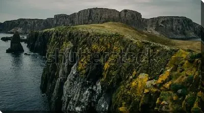 Постер Скалы на берегу моря с зелёным и оранжевым мхом на острове Скай (Шотландия)