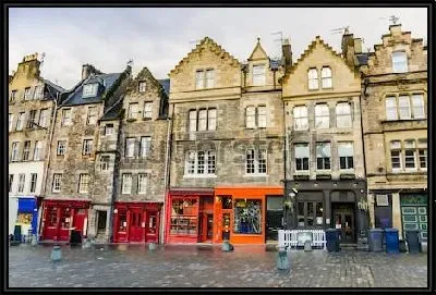 Улочка с историческими домами и красочными витринами магазинов в Старом городе Эдинбурга (Шотландия)