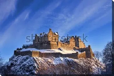 Величественный Эдинбургский замок на фоне яркого голубого зимнего неба