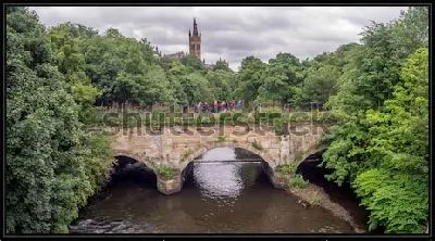 Картина Великолепный пейзаж со старинным арочным мостом через реку в зелёном парке с видом на башню Университета (Глазго, Шотландия)