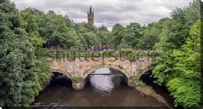 Постер Великолепный пейзаж со старинным арочным мостом через реку в зелёном парке с видом на башню Университета (Глазго, Шотландия)