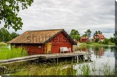 Живописный берег водоёма с типичными шведскими деревянными домиками в северной части Стокгольмского архипелага (Швеция)