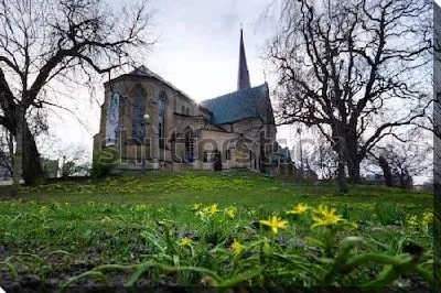 Мистический пейзаж с собором Хагачуркан в окружении деревьев и жёлтыми первоцветами на первом плане (Гётеборг, Швеция)