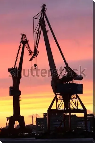 Постер Силуэты кранов в гавани Гётеборга на фоне великолепного красочного заката (Швеция)