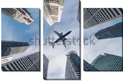 Модульная картина Самолёт в окружении небоскрёбов - вид снизу вверх