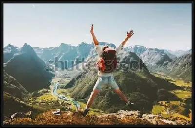 Счастливый путешественник с рюкзаком радуется покорению горной вершины и любуется великолепным видом на каьон