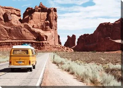 Автомобиль едет по трассе в каньоне