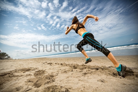 Постер Девушка бегун во время активной тренировки на красивом пляже 