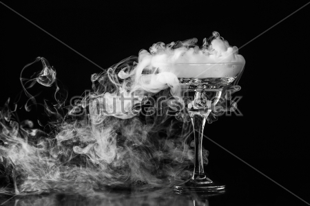 Постер Эффектный туман из красивого стеклянного бокала на тёмном фоне - химическая реакция сухого льда с водой  