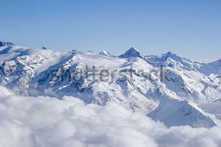 Постер Великолепный пейзаж с заснеженными вершинами Французских Альп над облаками в зимний солнечный день  