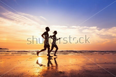 Картина Молодая пара совершает пробежку по пляжу на фоне красивого закатного неба 