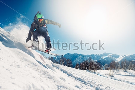 Картина Сноубордист прыгает со сноубордом на фоне заснеженных гор 